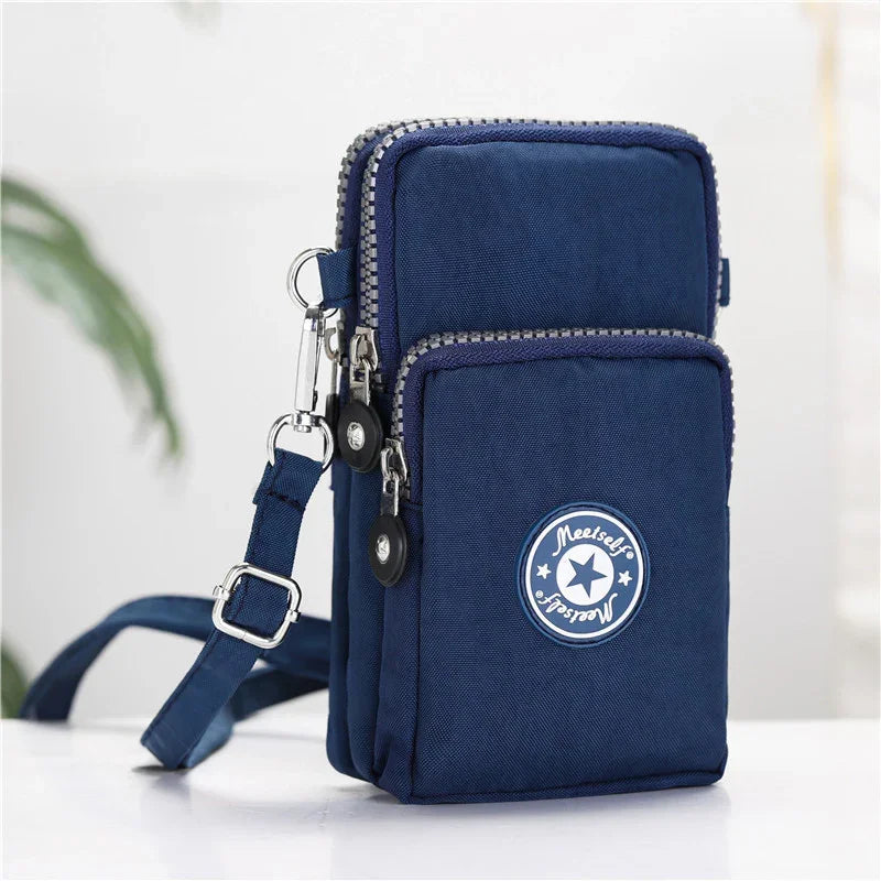 Navy blue crossbody bag with dual zipper compartments and adjustable strap on white surface