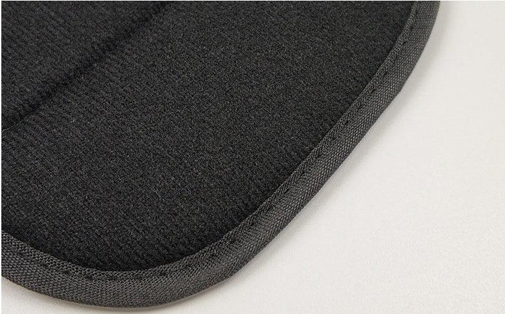 Close-up of black textured fabric edge with reinforced binding on light surface