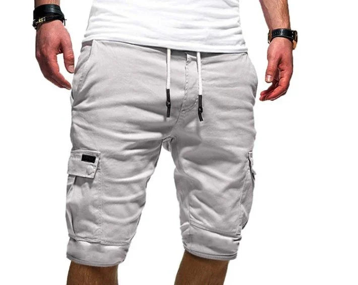 Man wearing light gray cargo shorts with side pockets and white drawstring waist with black tips