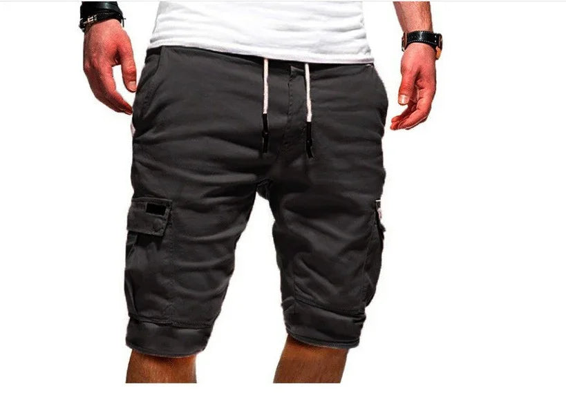 Man wearing black cargo shorts with pockets and white drawstring, paired with a white t-shirt and wristwatch