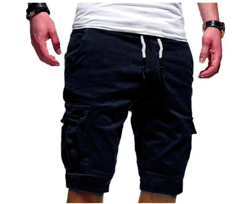 Man wearing black cargo shorts with drawstring waist and large side pockets, paired with a white t-shirt