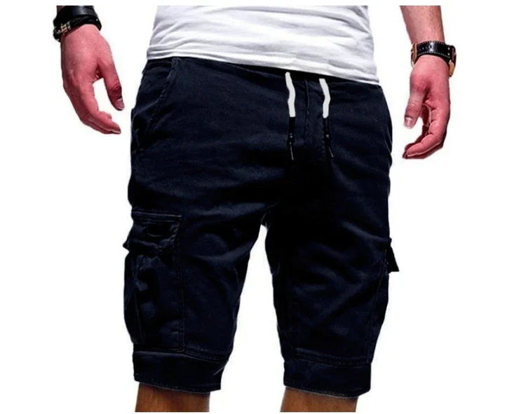 Man wearing black cargo shorts with drawstring waist and large side pockets, paired with a white t-shirt