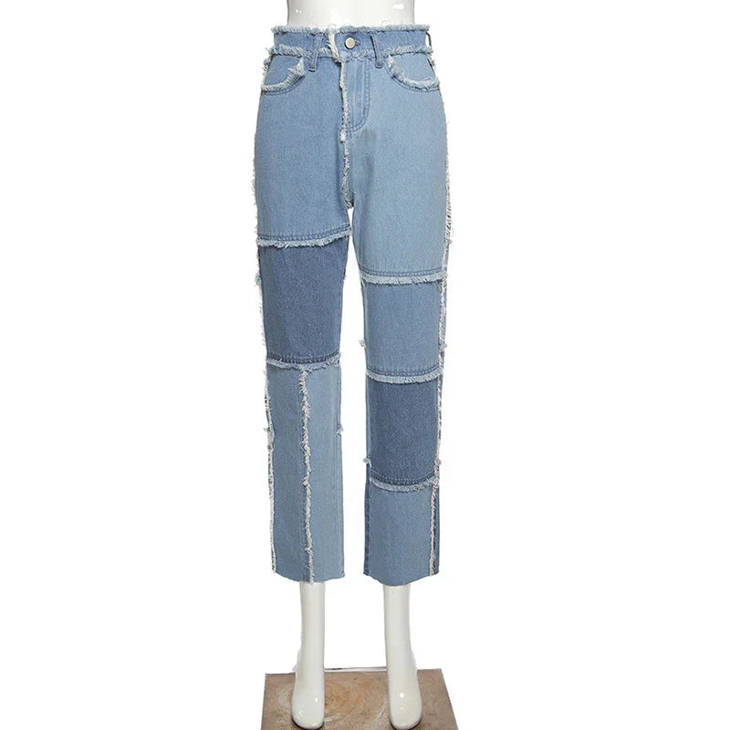 High-waisted patchwork denim jeans with frayed edges on mannequin