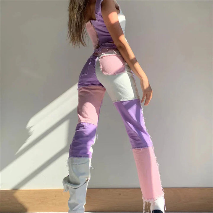 Woman wearing patchwork pink, purple, and white distressed jeans with light gray boots against white wall