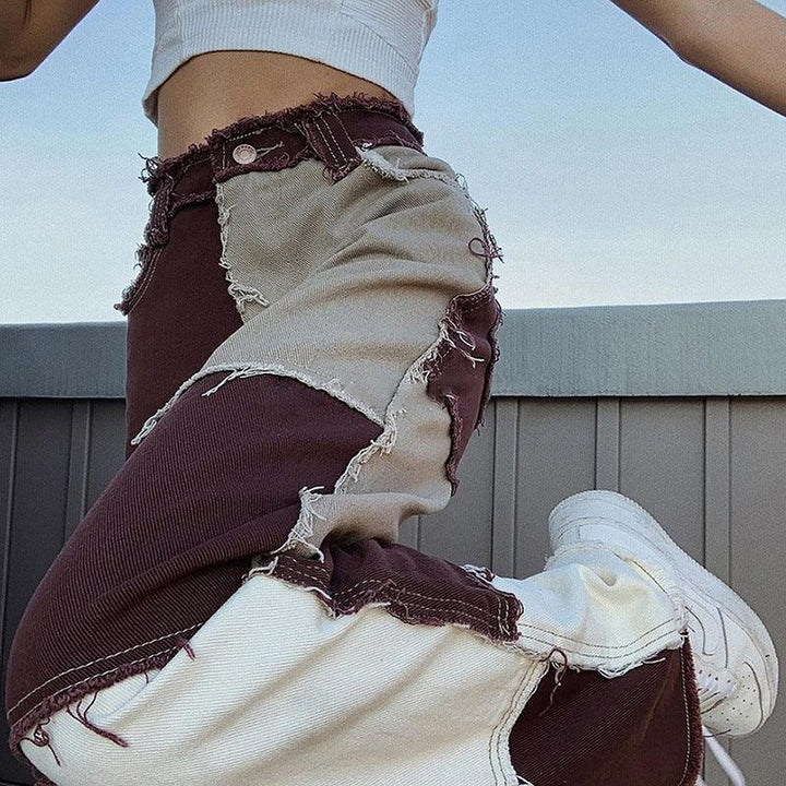Close-up of woman wearing high-waisted patchwork corduroy pants in brown and beige with white sneakers outdoors