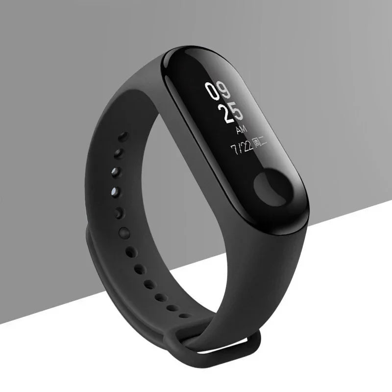 Black fitness tracker smartwatch with digital display showing time and date on gray background