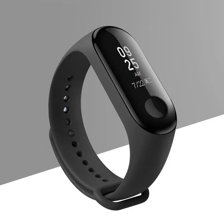 Black fitness tracker smartwatch with digital display showing time and date on gray background
