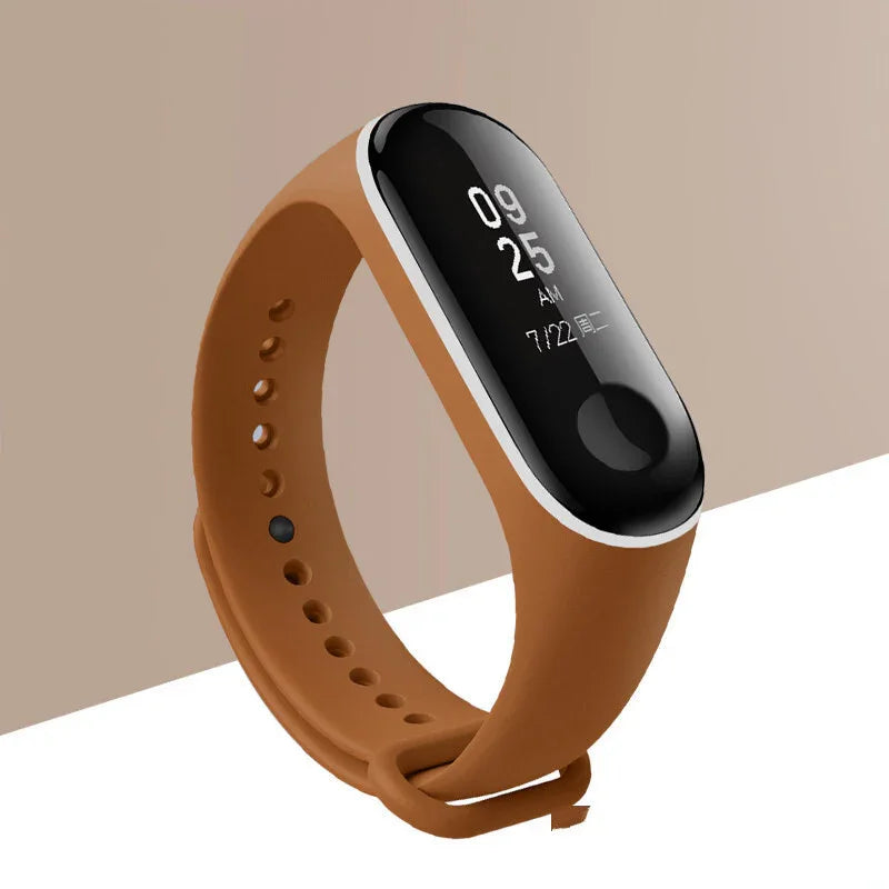 Brown fitness tracker with black screen displaying time and date on beige background