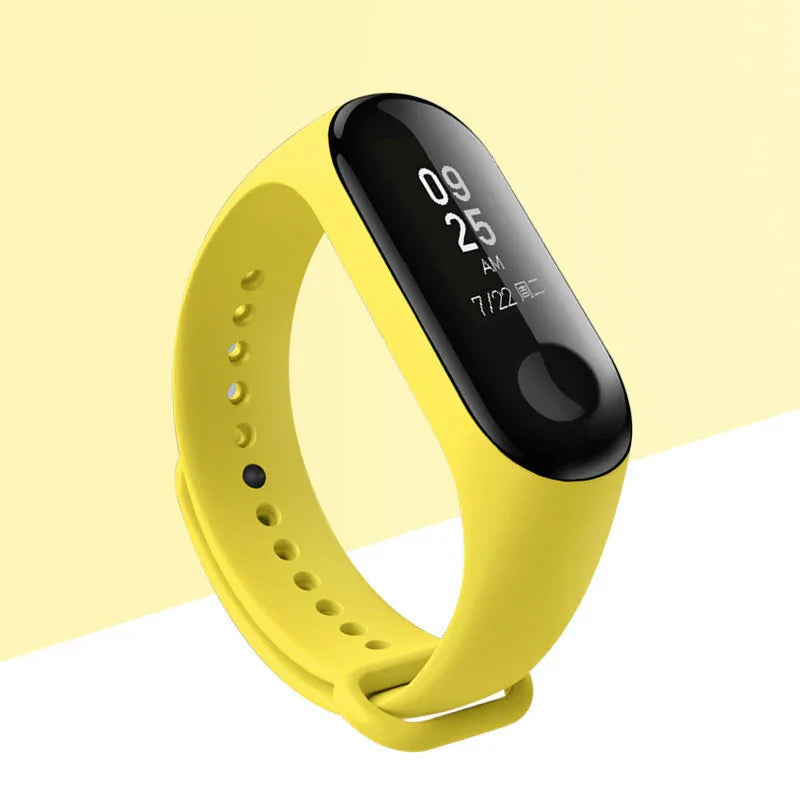 Yellow fitness tracker with black screen displaying time and date on light yellow background
