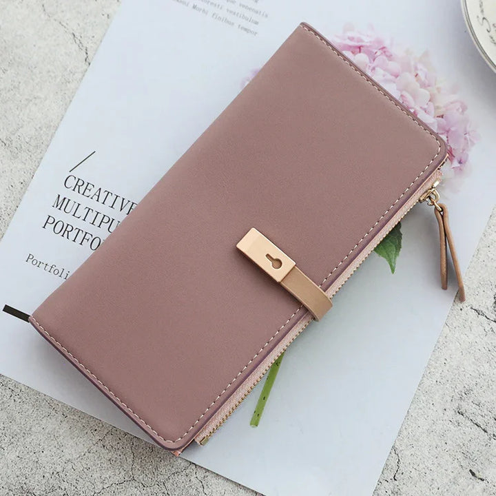 Pink leather wallet with gold lock detail on creative portfolio paper background