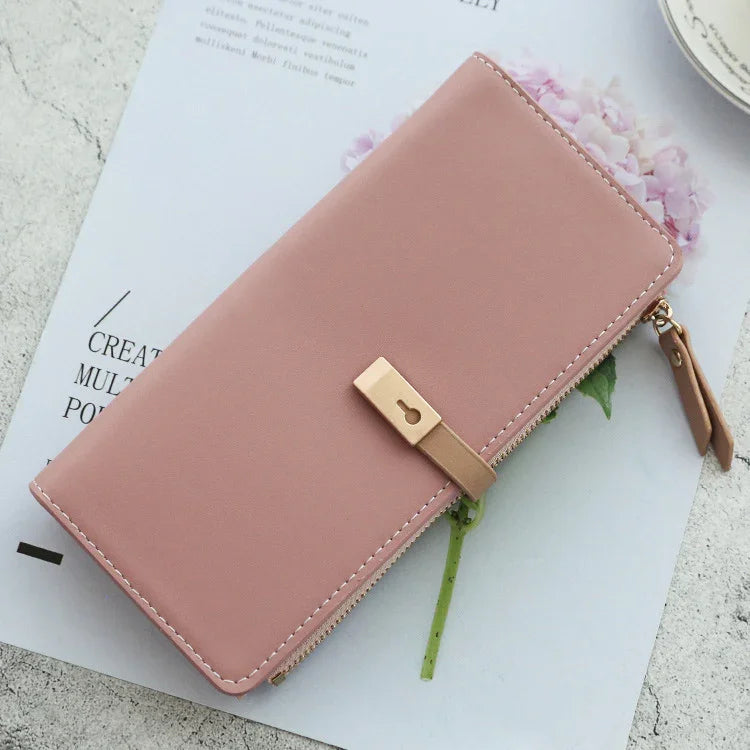 elegant pink leather zippered wallet with gold keyhole lock on white paper with flower detail