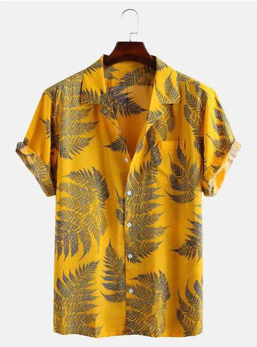Yellow short sleeve button-up shirt with dark green fern leaf print on wooden hanger