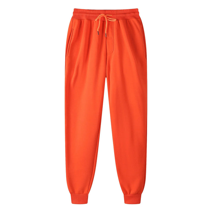Bright orange jogger sweatpants with drawstring waist and ribbed cuffs on white background