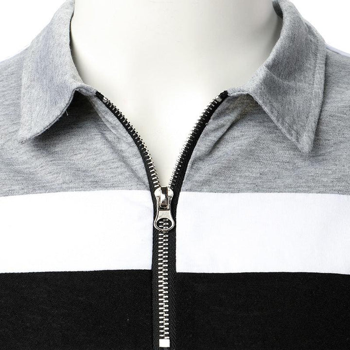 Close-up of grey, white, and black color-blocked pullover with silver zipper and collar