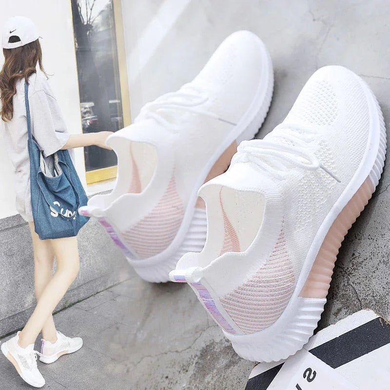 White knitted sneakers with thick soles on concrete floor and woman wearing them with casual outfit