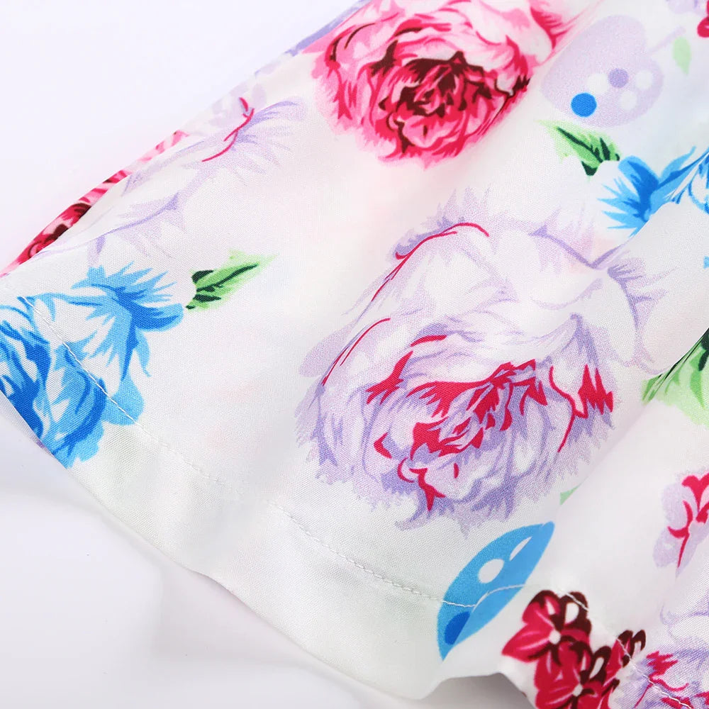 Close-up of white fabric with colorful floral print including pink, blue, and red flowers on smooth material
