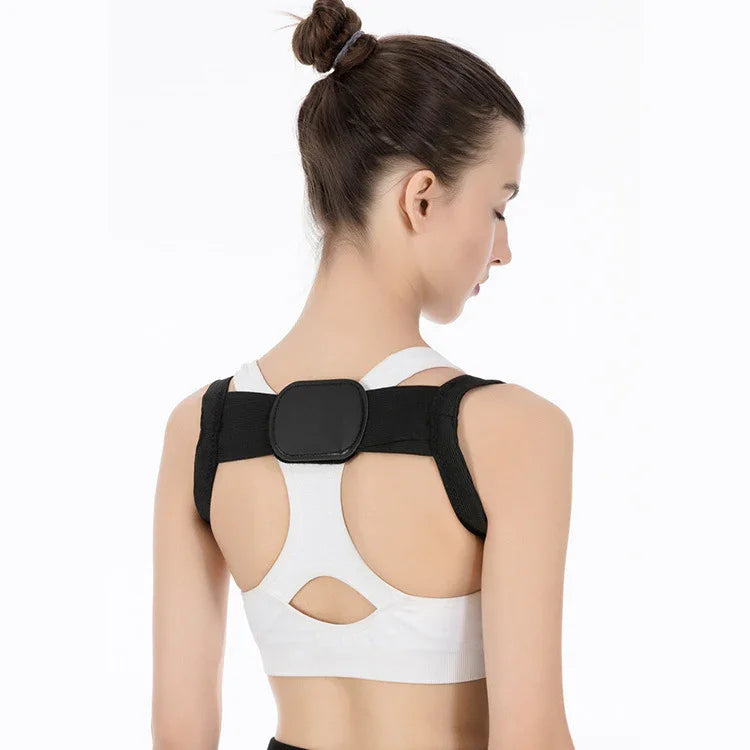 Woman wearing black posture corrector brace over white sports bra on white background