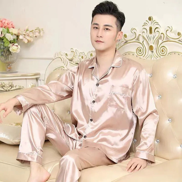 Man wearing shiny beige satin pajamas sitting on an ornate cream sofa with floral decor