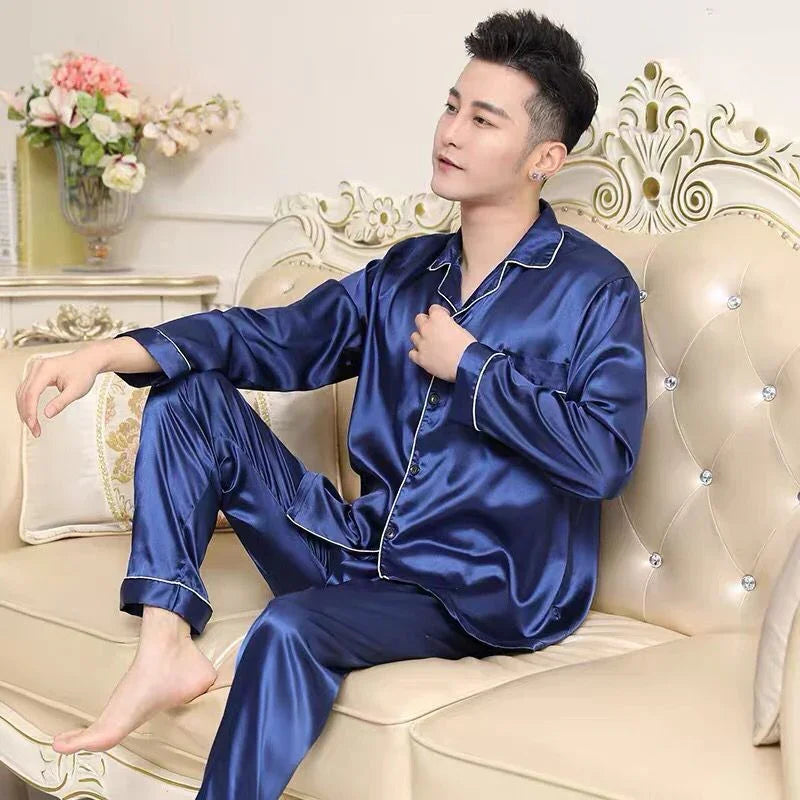 Man sitting on beige tufted sofa wearing blue satin pajamas in elegant living room