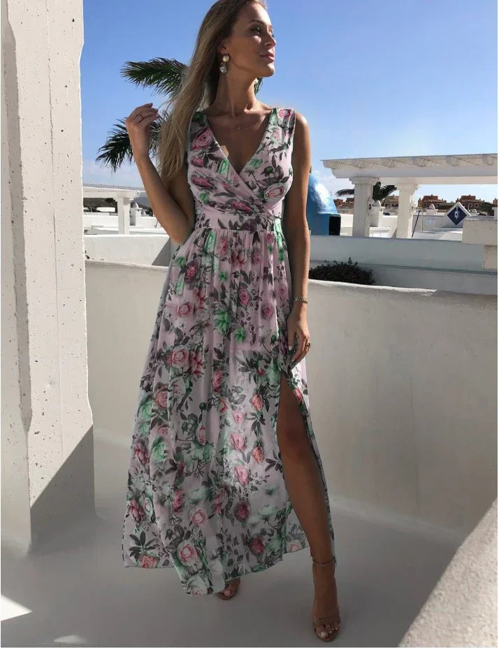Woman wearing a sleeveless floral maxi dress with a thigh-high slit standing outdoors in sunny weather
