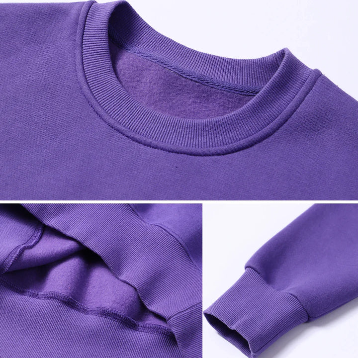 Close-up of purple crewneck sweatshirt showing ribbed collar, cuff, and soft fleece interior