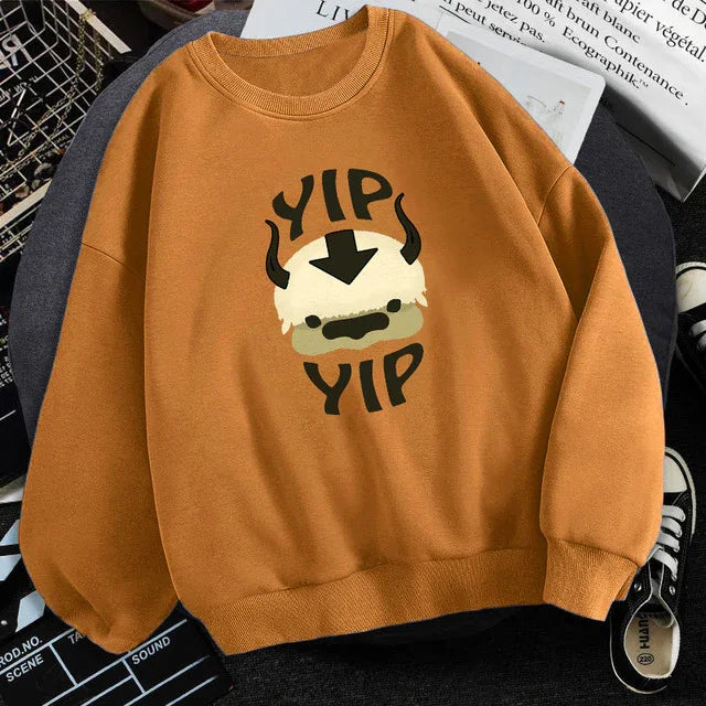brown sweatshirt with cartoon Appa from Avatar and text YIP YIP in black
