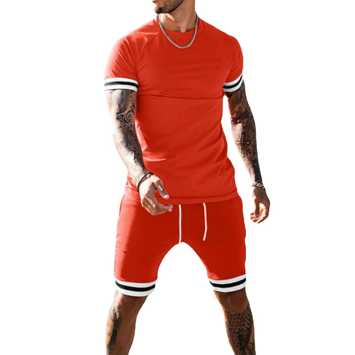 Man wearing red casual t-shirt and shorts set with black and white striped cuffs, tattooed arms and legs
