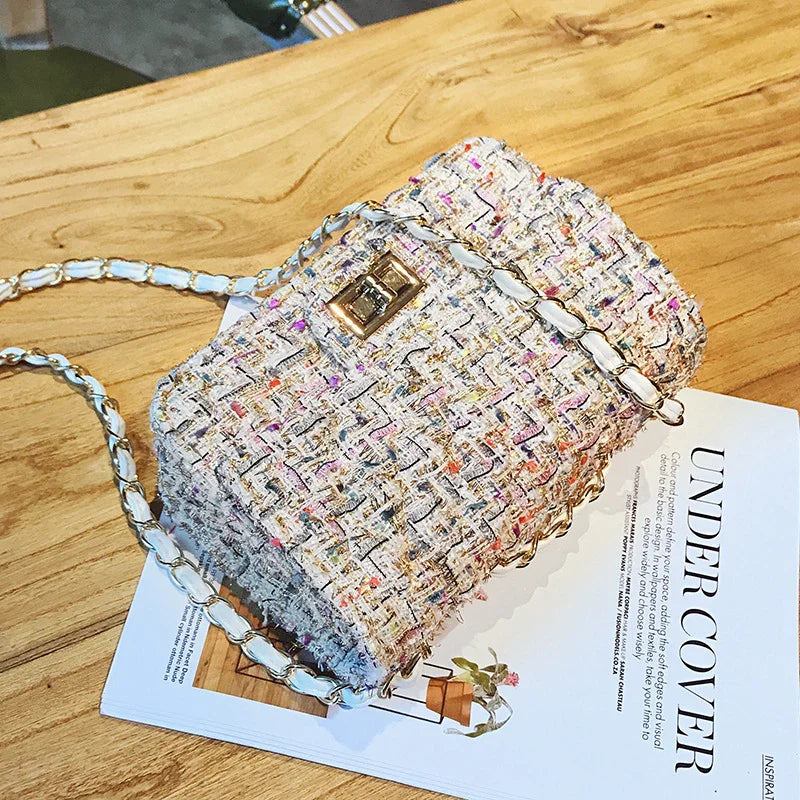Colorful tweed chain shoulder bag with gold clasp on wooden table over magazine