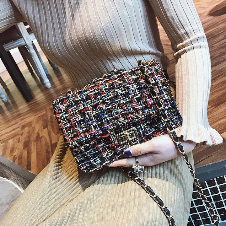 Woman wearing beige ribbed outfit holding multicolor tweed handbag with chain strap indoors