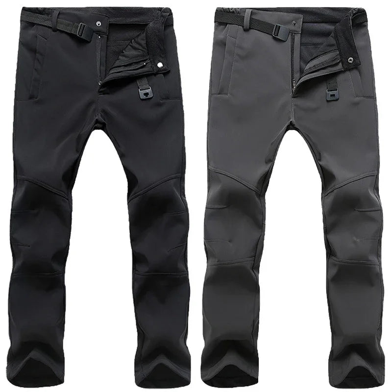 Two pairs of outdoor softshell pants in black and grey with reinforced knees and adjustable waist straps