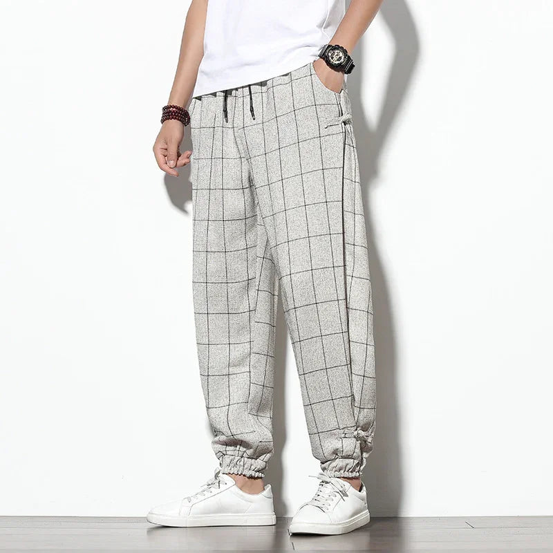 Men's casual gray checkered jogger pants with elastic cuffs and white sneakers