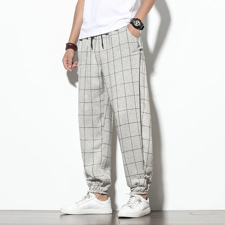 Men's casual gray checkered jogger pants with elastic cuffs and white sneakers