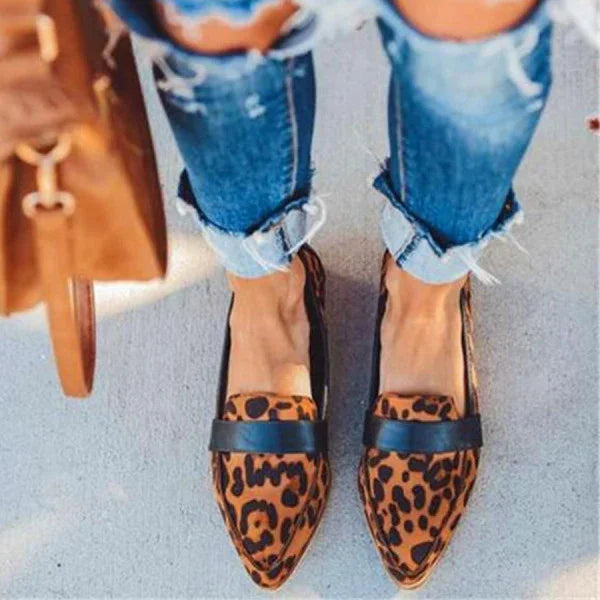 Womens leopard print pointed loafers paired with cuffed distressed blue jeans and a brown leather bag