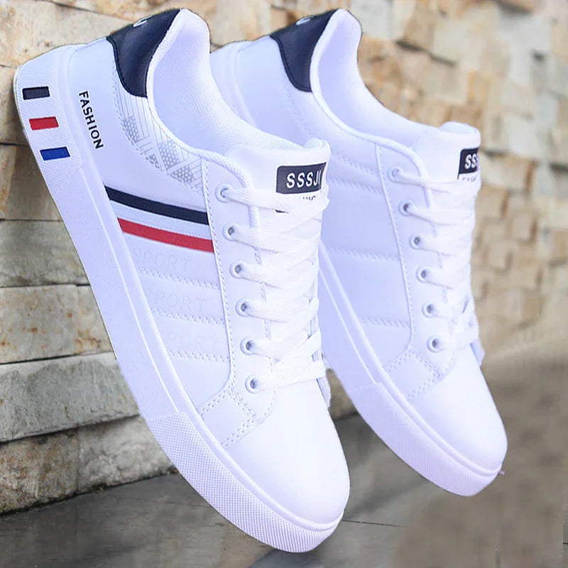 White casual sneakers with red, blue, and black stripes and 'FASHION' text on sole against stone wall