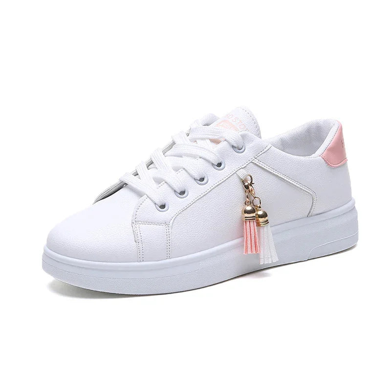 White casual sneaker with pink heel accent and decorative pink and white tassels