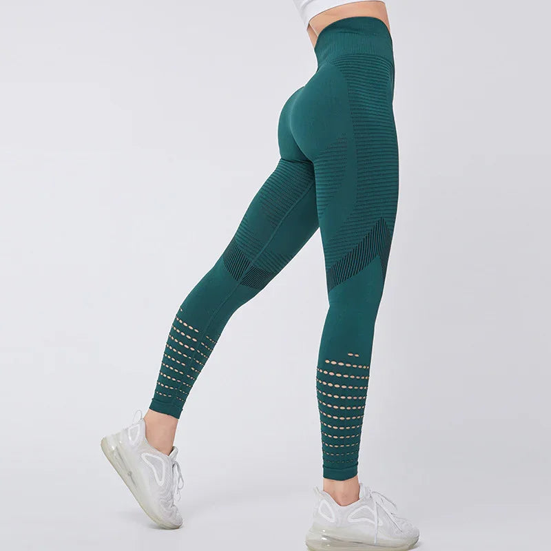 Woman wearing seamless green leggings with ventilation holes and white sneakers against a white background