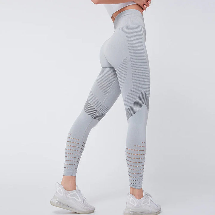 Woman wearing light gray seamless high-waisted leggings with striped and perforated patterns, white sneakers