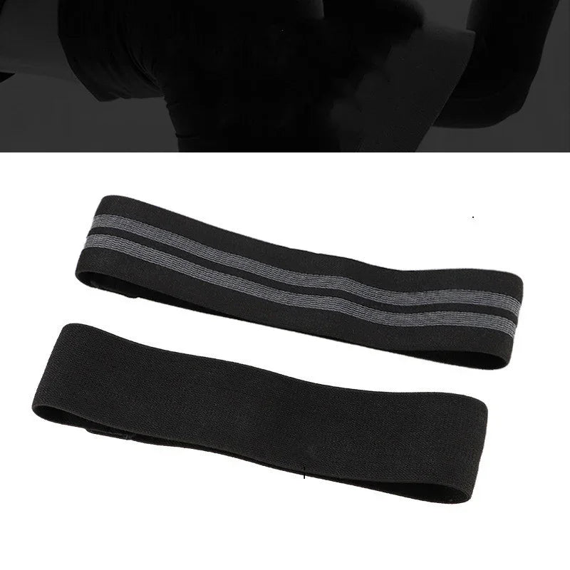 Two black resistance bands for exercise, one with gray stripes, on a white background