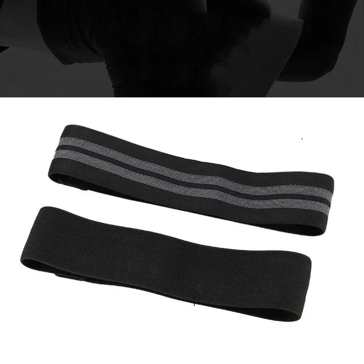 Two black resistance bands for exercise, one with gray stripes, on a white background