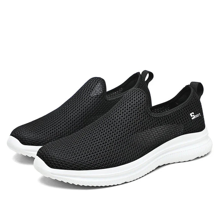 Black breathable mesh slip-on sport sneakers with white sole and pull tabs