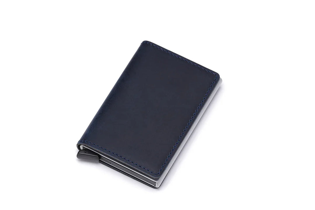 Compact navy blue leather wallet with stitched edges on white background