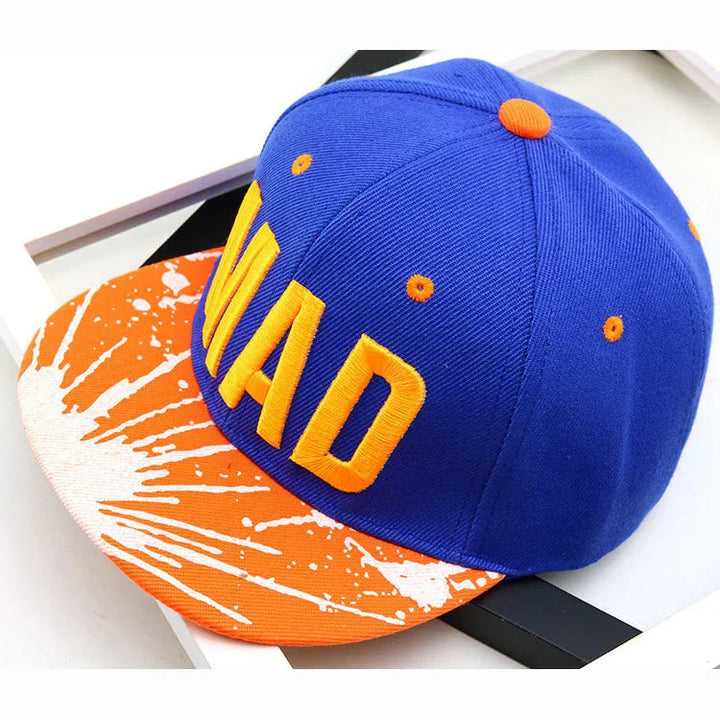 Blue and orange snapback cap with bold yellow embroidered text and unique splatter pattern brim