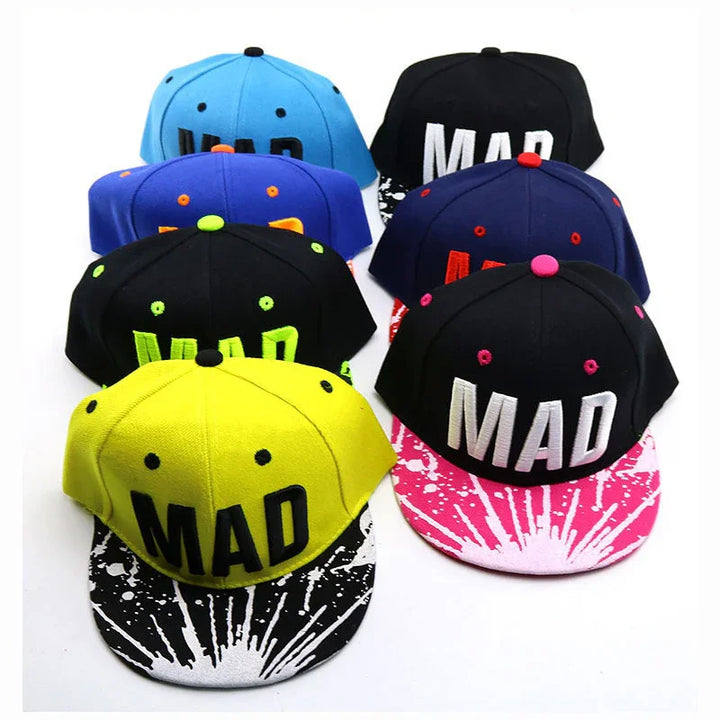 Colorful MAD snapback caps with black and pink or black and white splatter brims arranged in rows