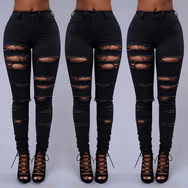 Front view of black distressed skinny jeans with multiple ripped details worn with black lace-up heels