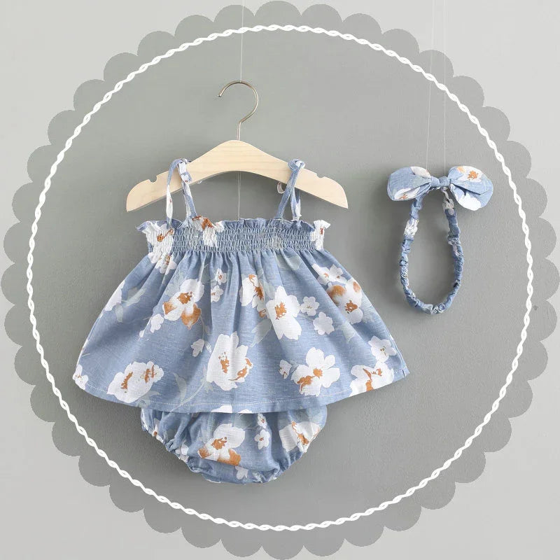 Blue floral baby dress with matching bloomers and headband on gray background