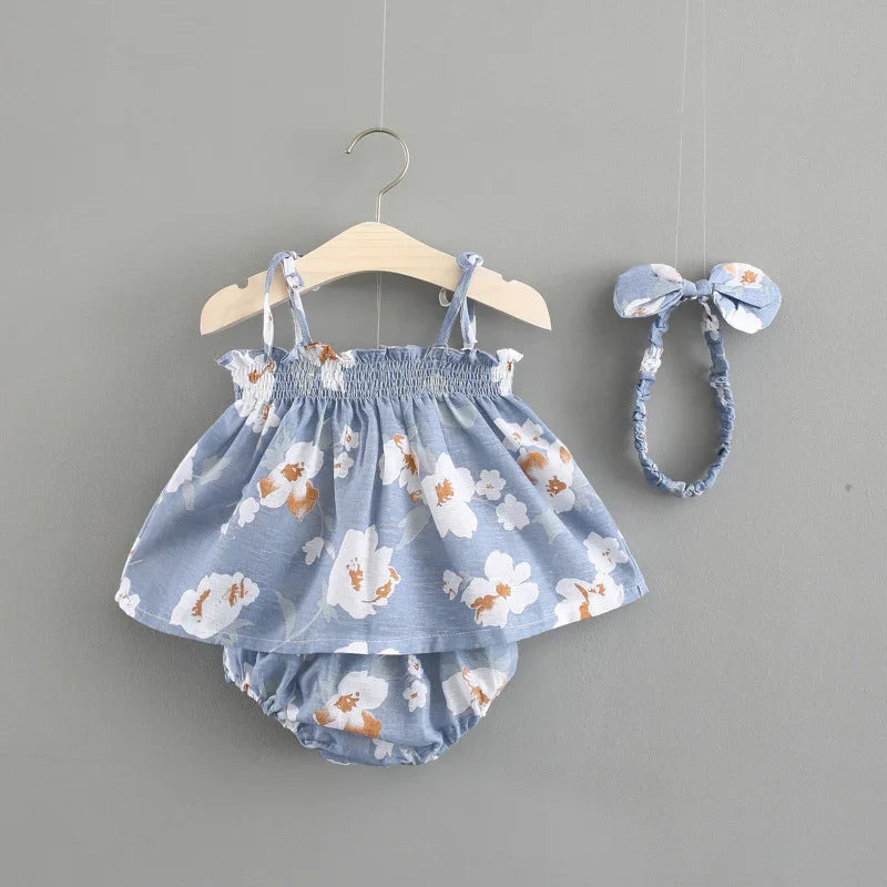 Blue floral printed baby dress with matching headband on gray background
