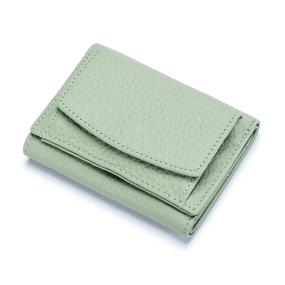 Folded mint green textured leather wallet with stitched edges on white background