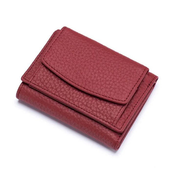 Compact red leather wallet with textured finish and flap closure on white background