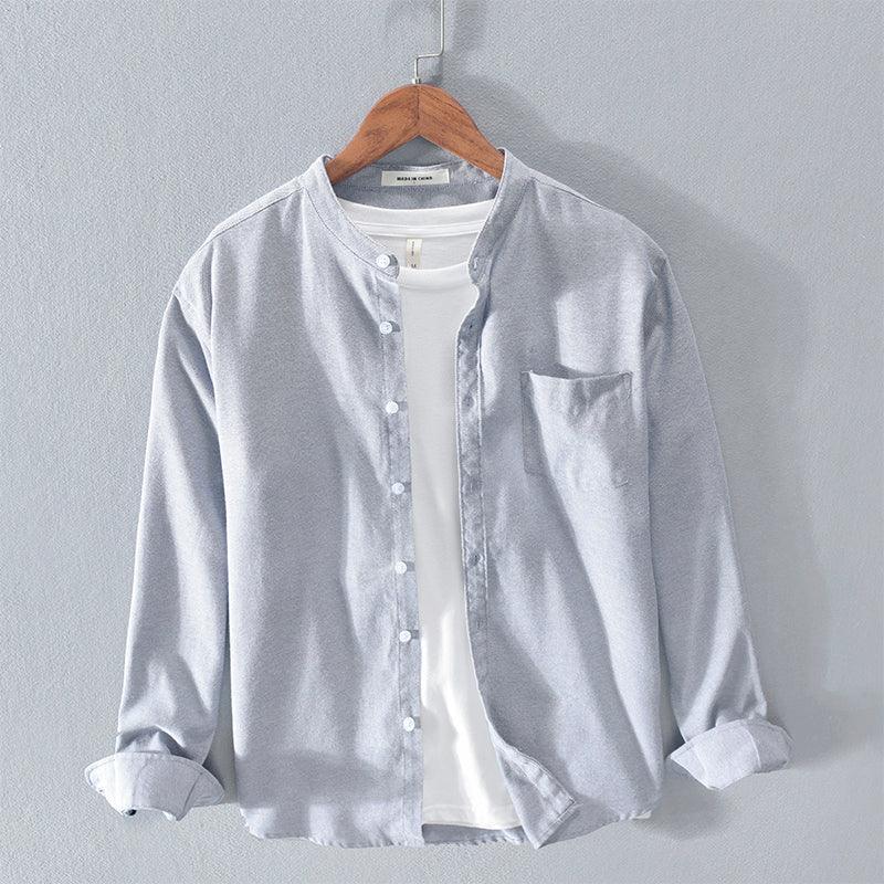Light gray button-up shirt with mandarin collar over white t-shirt on wooden hanger