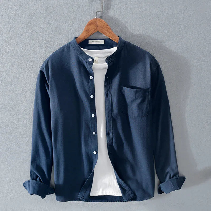 Navy blue casual button-up shirt with white buttons and chest pocket, layered over white T-shirt on wooden hanger